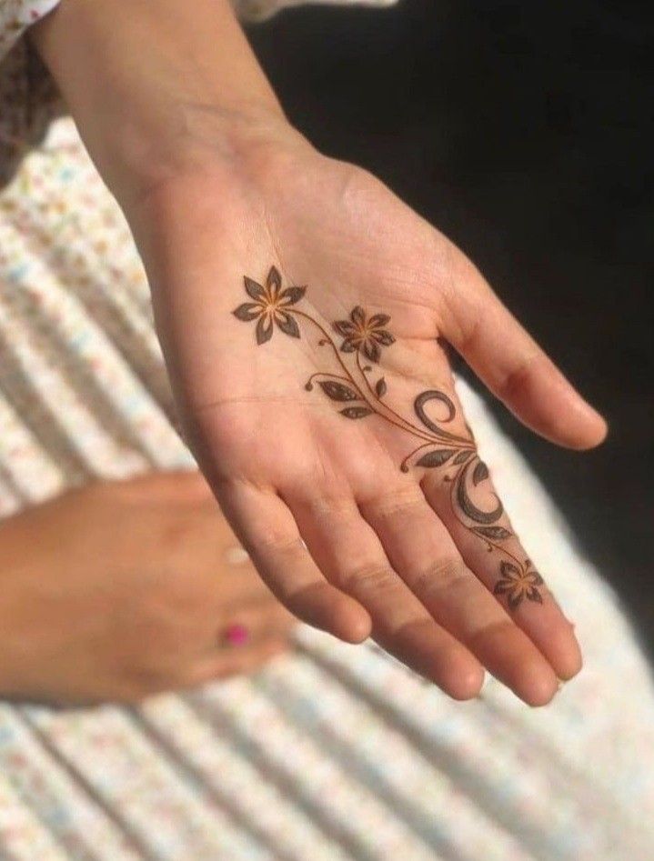 a woman's hand with flowers painted on it