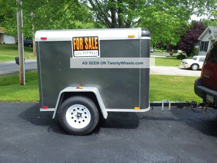 an enclosed trailer is parked in the driveway