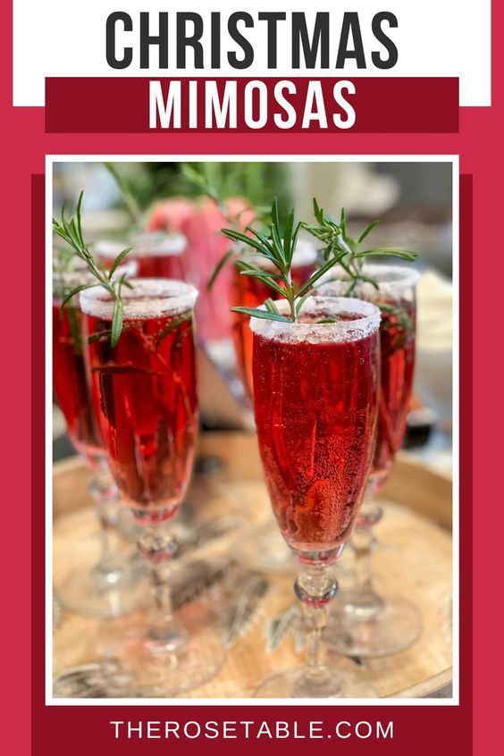 three glasses filled with red wine and garnished with rosemary sprigs on top