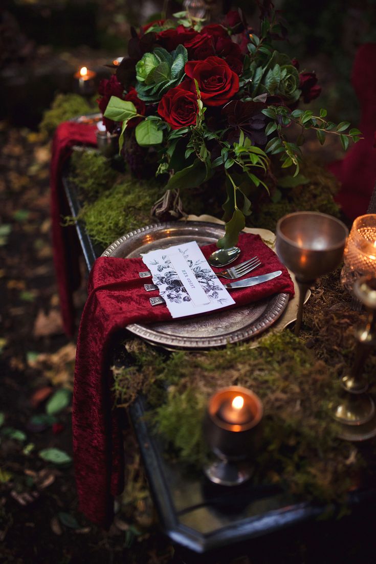 the table is set with candles, flowers and menu cards for dinner or an event