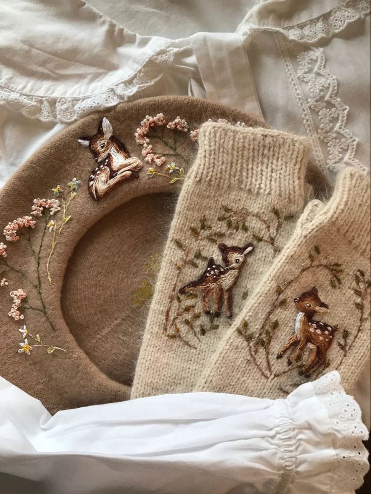 two knitted deer mitts are laying on a bed