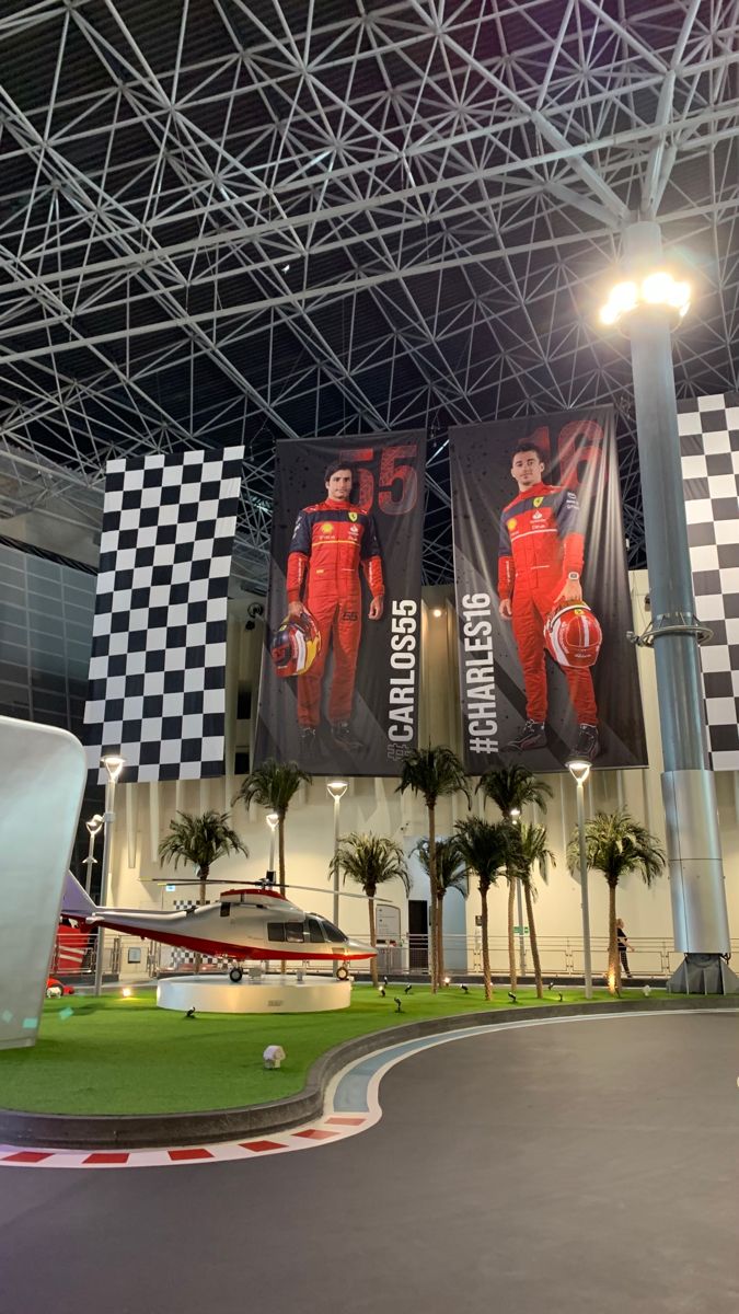 an indoor race track with banners on the ceiling