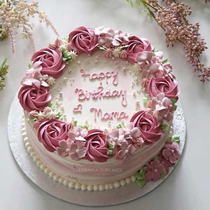 a birthday cake decorated with pink flowers on a table