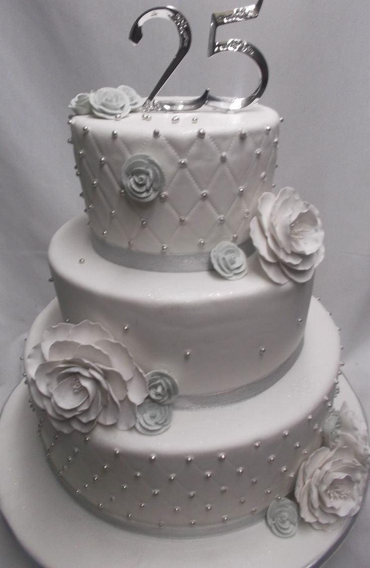 a three tiered white wedding cake with roses on it and the number twenty two