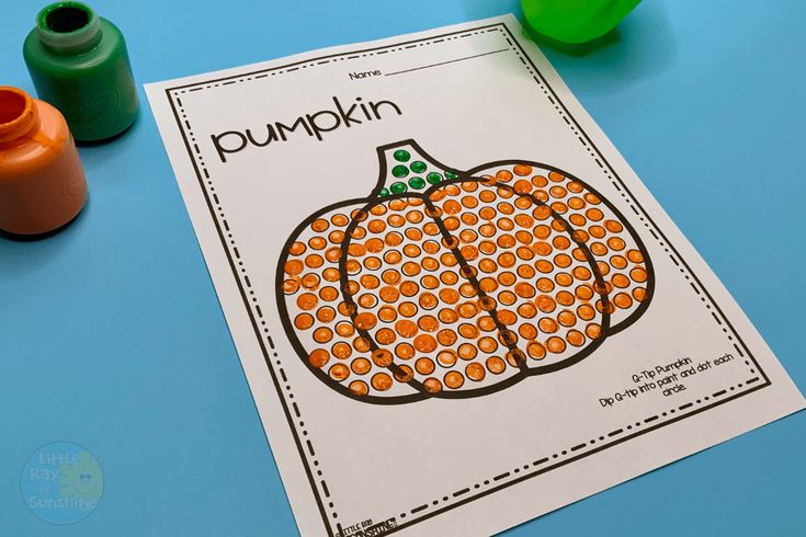 an orange pumpkin is on the table next to some markers