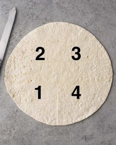 an uncooked tortilla with numbers on it and a knife next to it