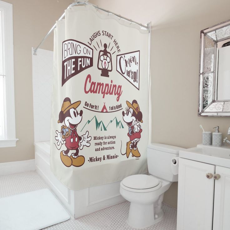 a bathroom with a toilet, sink and shower curtain in the shape of mickey mouse