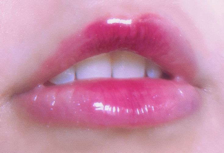 a close up view of a woman's lips with bright pink lipstick on it