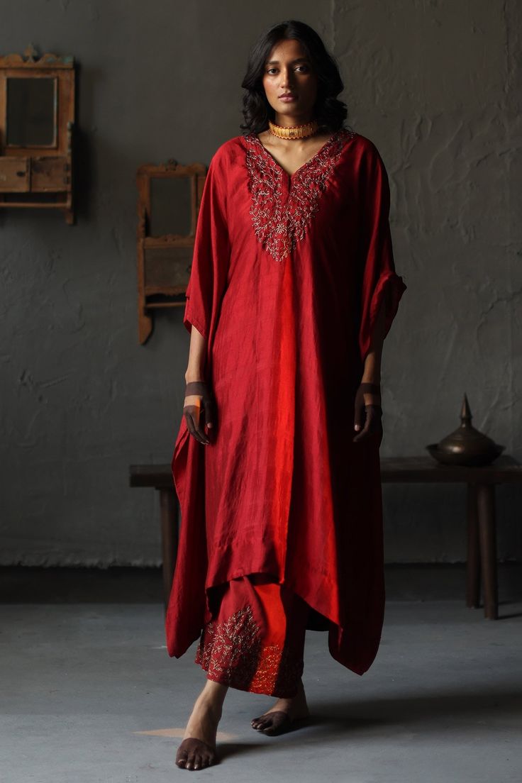 Ruby red kaftan with embroidery in a floral pattern and asymmetrical hem. Comes with co-ordinating farshi pants.
Component: 2
Pattern: Embroidery
Type Of Work: Beads
Neckline: V neck
Sleeve Type: Kaftan Sleeves
Fabric: Kaftan: Mulberry Silk and Farshi: Cotton Silk; Lining: Shantoon
Color: Red
Other Details: 
Asymmetrical hem
Note: The yellow kaftan worn by the other model is not for sale
Occasion: Puja - Aza Fashions Kaftan And Pants, Shorshe Clothing, Kaftan With Pants, Yellow Kaftan, Red Kaftan, Kaftan Sleeves, V Neck Kaftan, Fashion 2025, Embroidered Kaftan