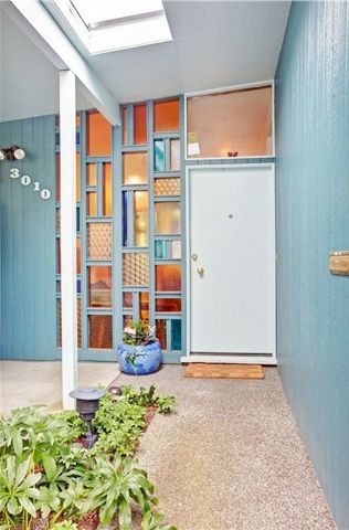 a hallway with blue walls and plants on the floor