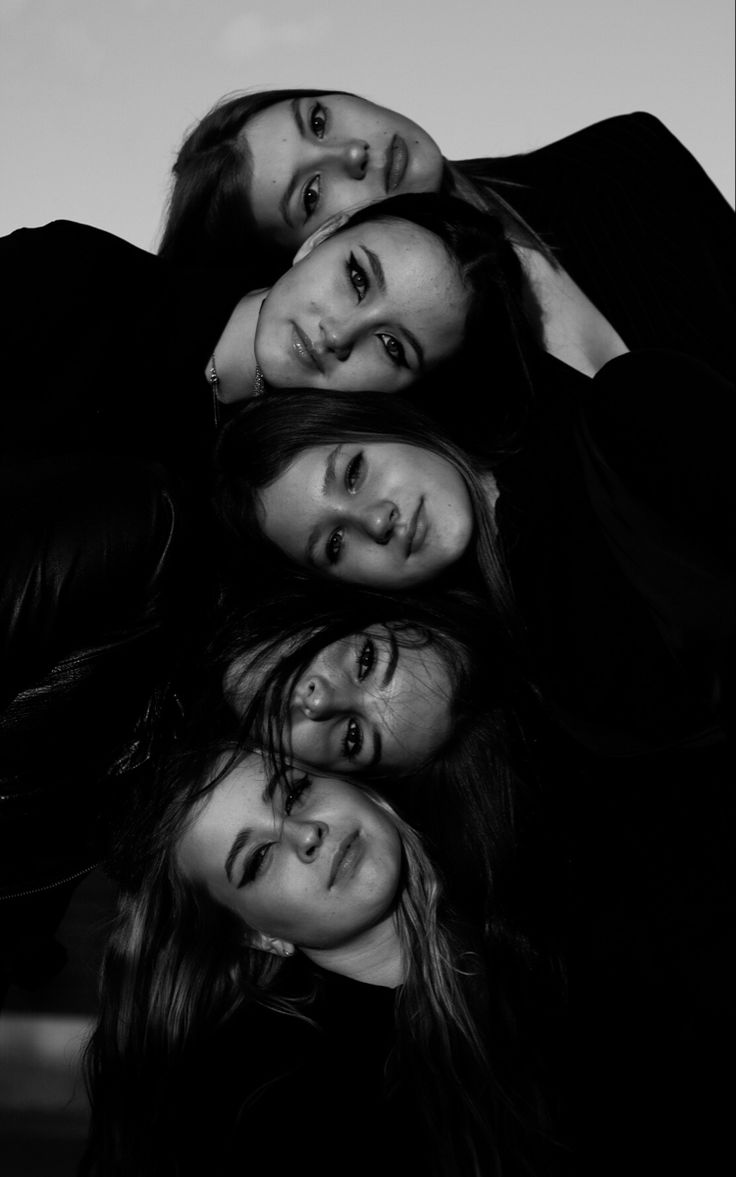 four people are posing for a black and white photo with their arms around each other