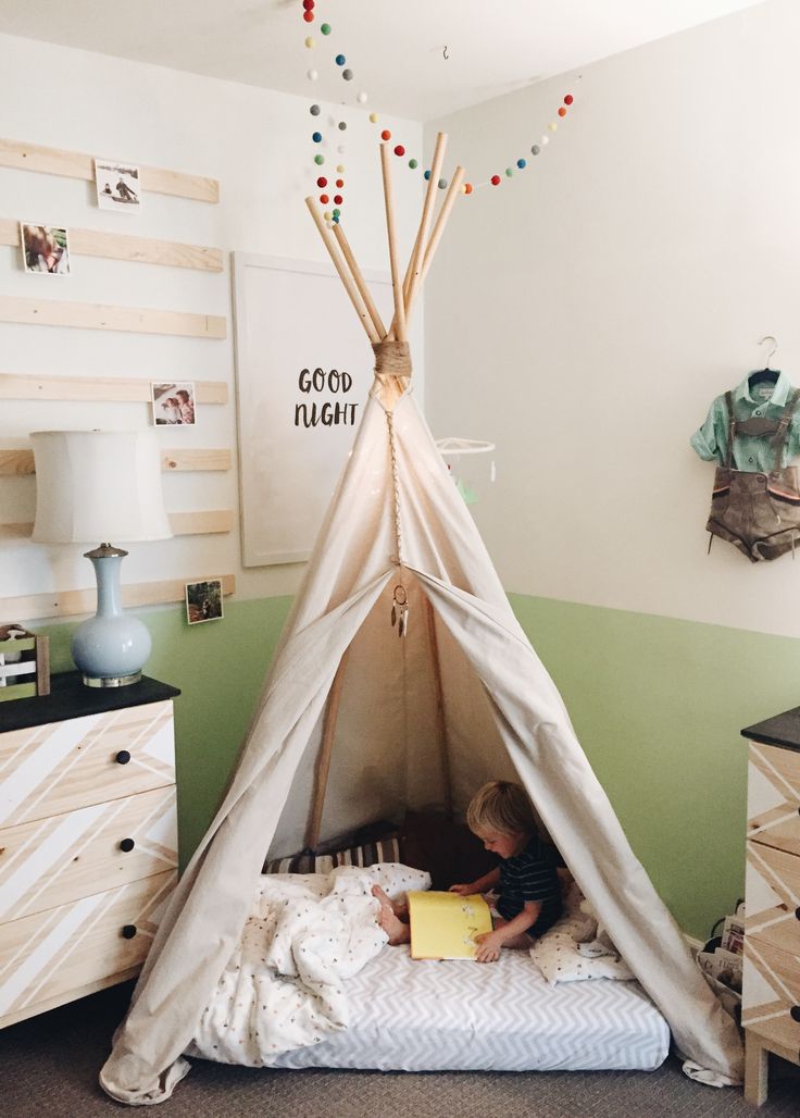 a little boy reading in his teepee bed