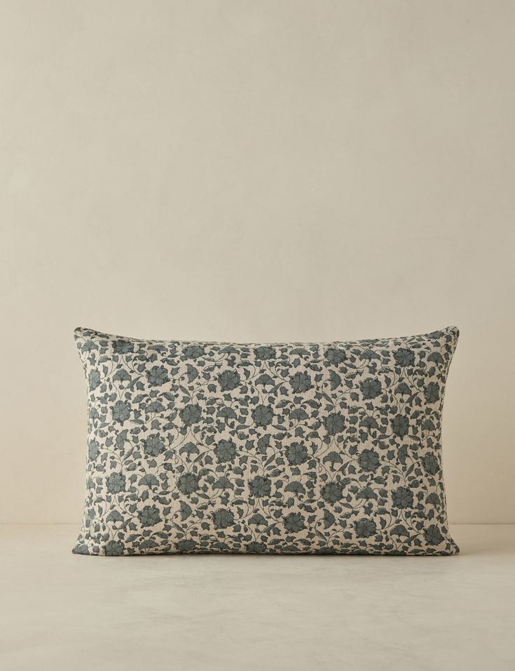 a blue and white pillow sitting on top of a table