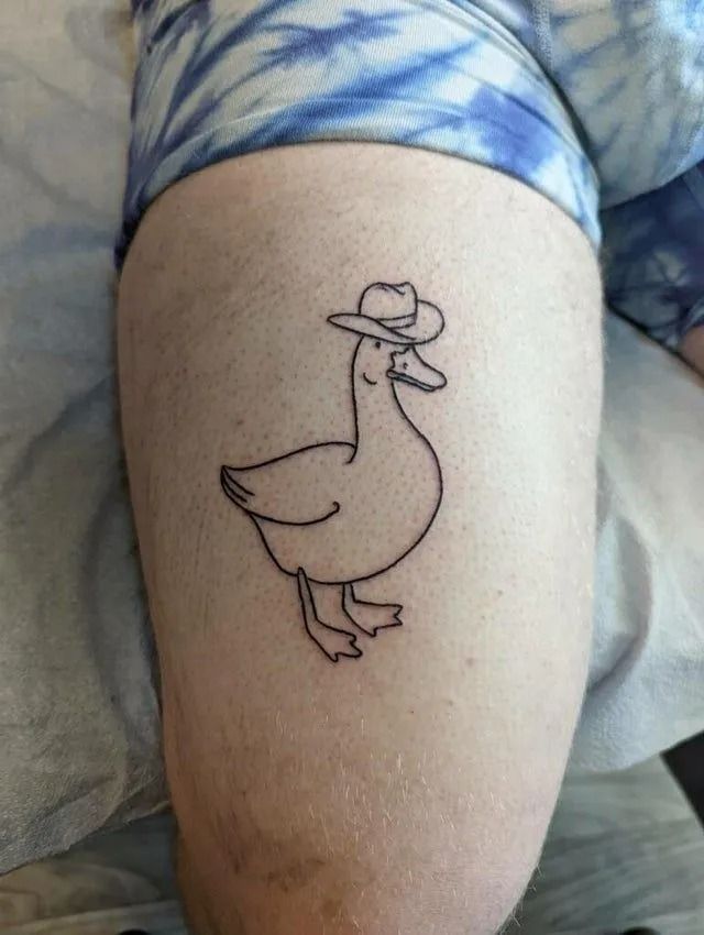 a duck with a hat on it's head sitting on a person's leg