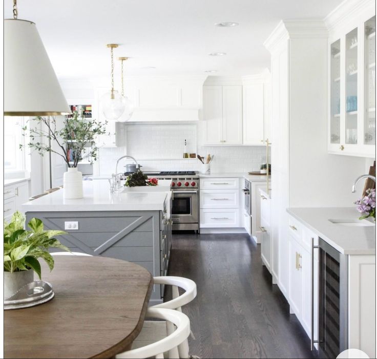 the kitchen is clean and ready for us to use it's white cabinets, wood floors, and stainless steel appliances