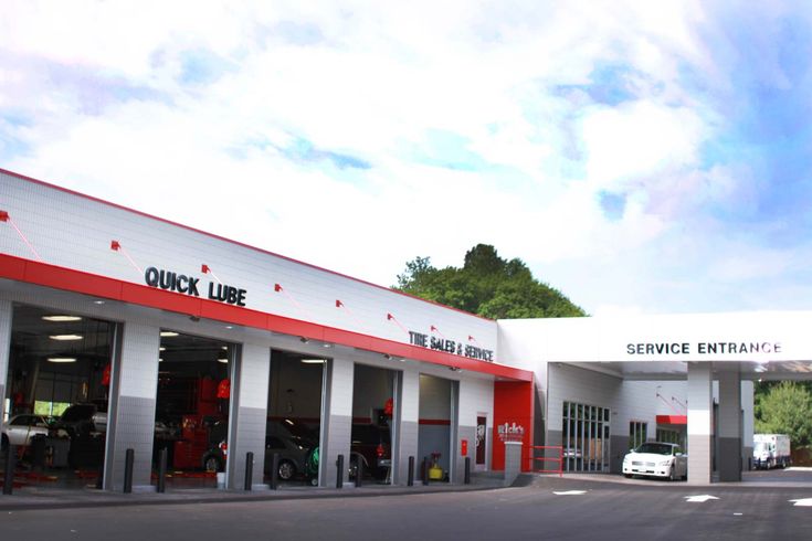 an image of a service station with cars parked in the garages and on the side