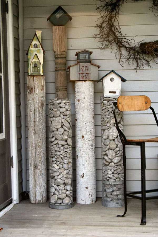 some bird houses are on the side of a house and there is a chair next to it