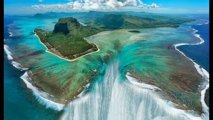 an island in the middle of water surrounded by mountains