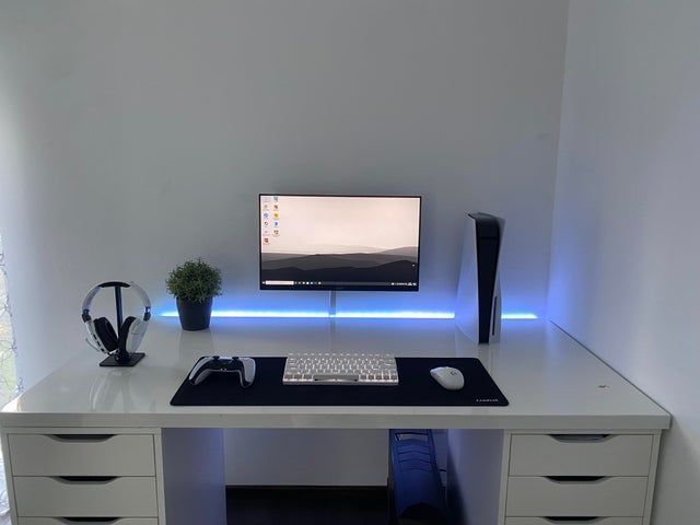 a desk with a computer and headphones on it