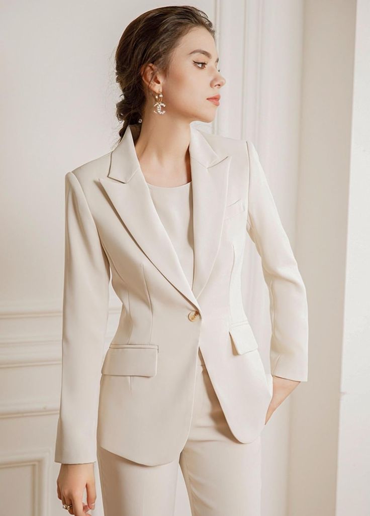 Experience luxury and sophistication in our Three Pcs Beige Pantsuit Set, featuring a beautiful silk blouse and pants made of the finest quality silk. Elevate your wardrobe with this exclusive set, perfect for any occasion. Three Pcs Beige Pantsuit Set Description: Peak lapels; front button blazer V-neck, Long sleeves; button cuffs. Structured shoulders. Chest welt pockets. Hip flap pockets Polyester 100% Silk blouse Wide leg loose fit pants Imported Brand - Aision Model Number - 22CPB82 Washing Cream Women Suits, Beige Suits Women, Outfit Jas, Beige Pantsuit, Coat Set For Women, Pantsuits For Women Business, Tailored Blazer Women, Cotton Tops Designs, Blouse And Pants