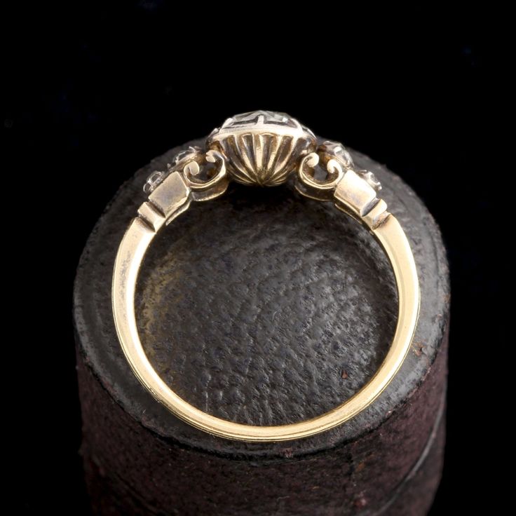 an antique diamond ring sits on top of a leather box