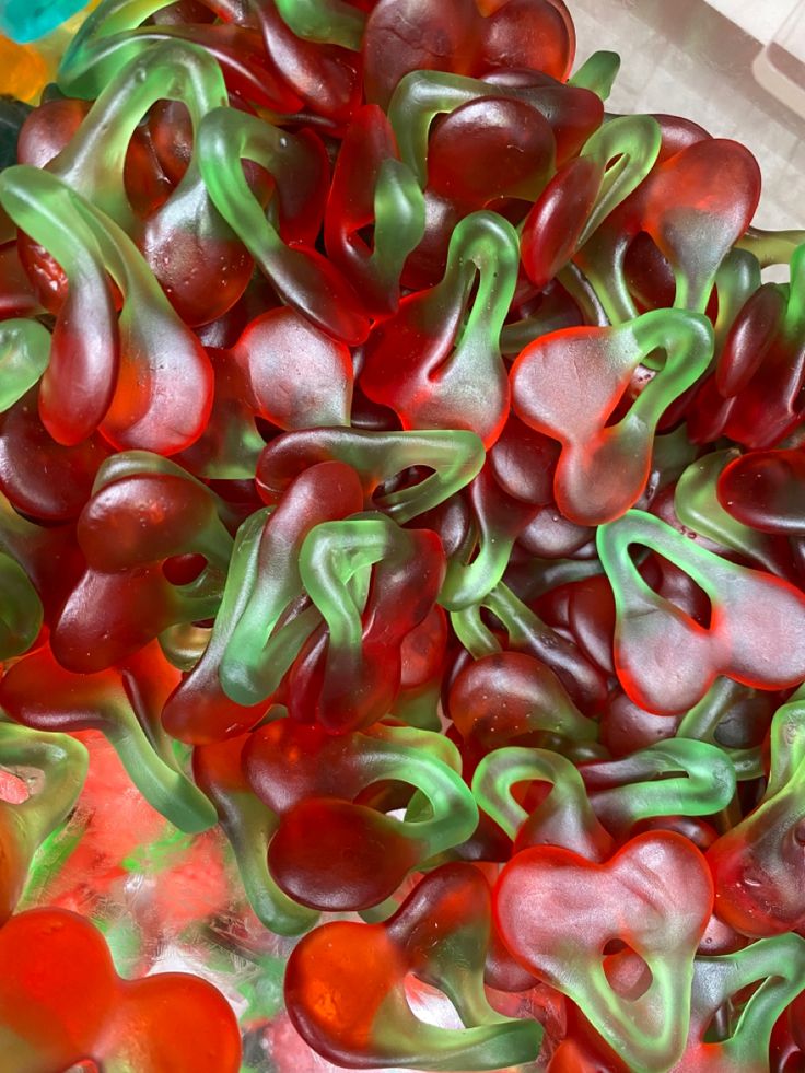 some red and green gummy bears in a bowl