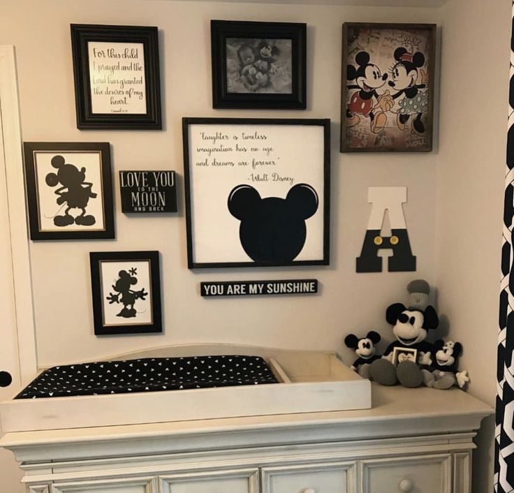 a baby's room with mickey mouse pictures on the wall