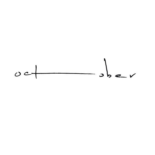 the word october written in cursive writing on a white paper with black ink