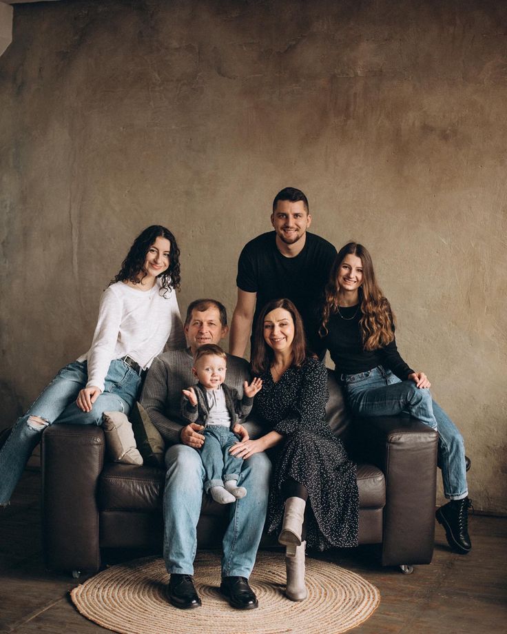 a family sitting on a couch in front of a wall