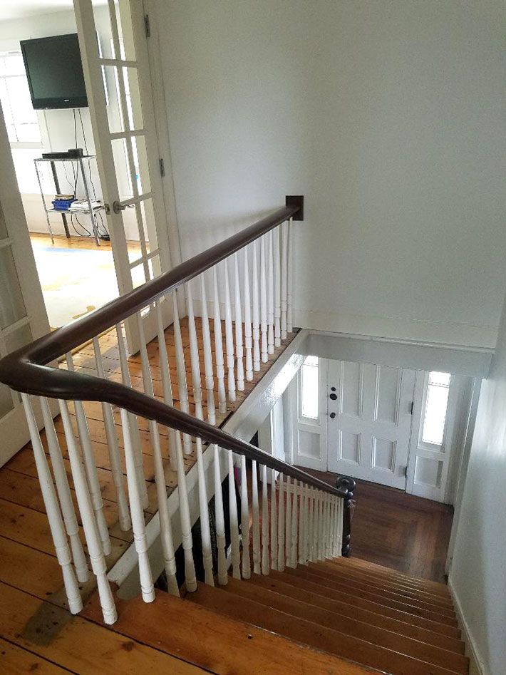 a white staircase with wooden handrails in a house