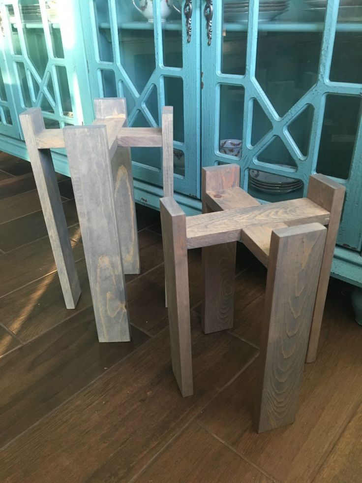 two wooden benches sitting next to each other on top of a hard wood floor in front of a glass door