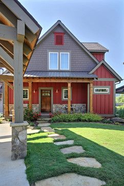 a red house with stone steps leading to the front door