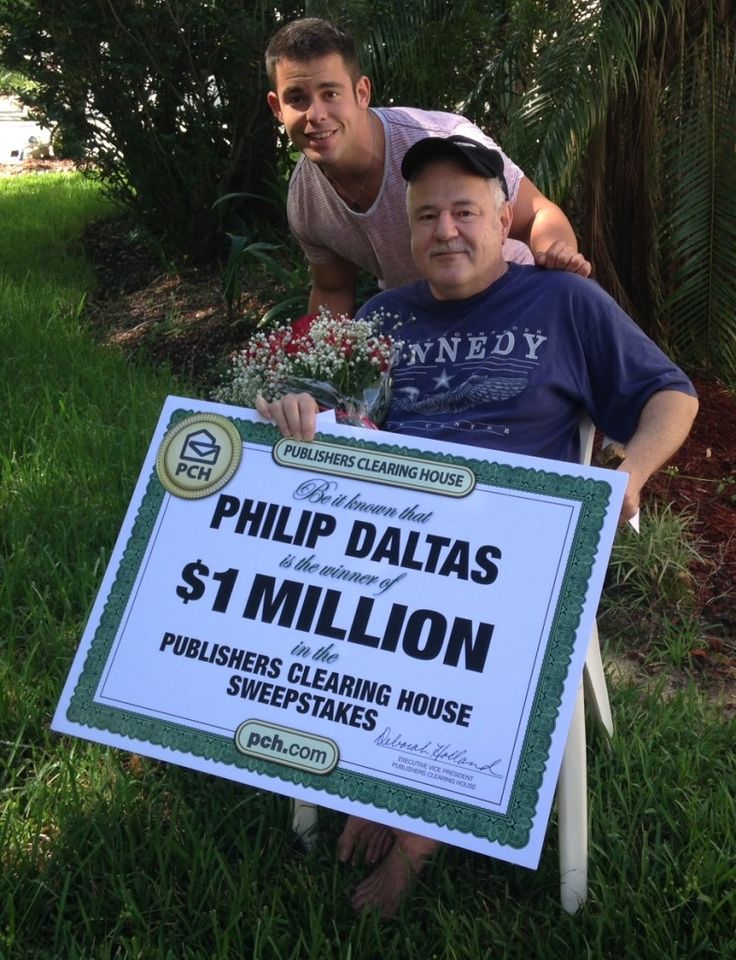 two men pose with a $ 1 million sign in front of their house for the camera