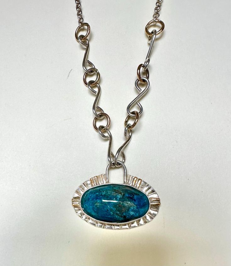 Beautiful AAA quality Azurite stone The oval stone stone has beautiful colors and sparkles throughout the stone and measures 1.5" wide, 1" tall and .25" deep. I have set the stone horizontally in a sterling silver bezel with 14k gold fill accents.  The handmade sterling silver bar chain is 18" in length with 3 bar on each side with  front hook closures that attach to the pendant. Each bar is 1.75 " in length with a 14k gold fill wire connecting each bar and is finished off around the back of the Chrysocolla Gemstone Oval Pendant Jewelry, Silver Oval Apatite Jewelry, Blue Chrysocolla Necklace With Large Stone, Oval Chrysocolla Necklace With Natural Stones, Blue Chrysocolla Jewelry With Large Stone, Blue Oval Agate Jewelry, Oval Blue Agate Jewelry, Handmade Oval Apatite Jewelry, Elegant Oval Chrysocolla Necklace