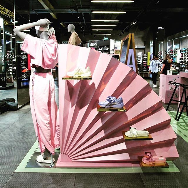 a mannequin is standing in front of a pink fan