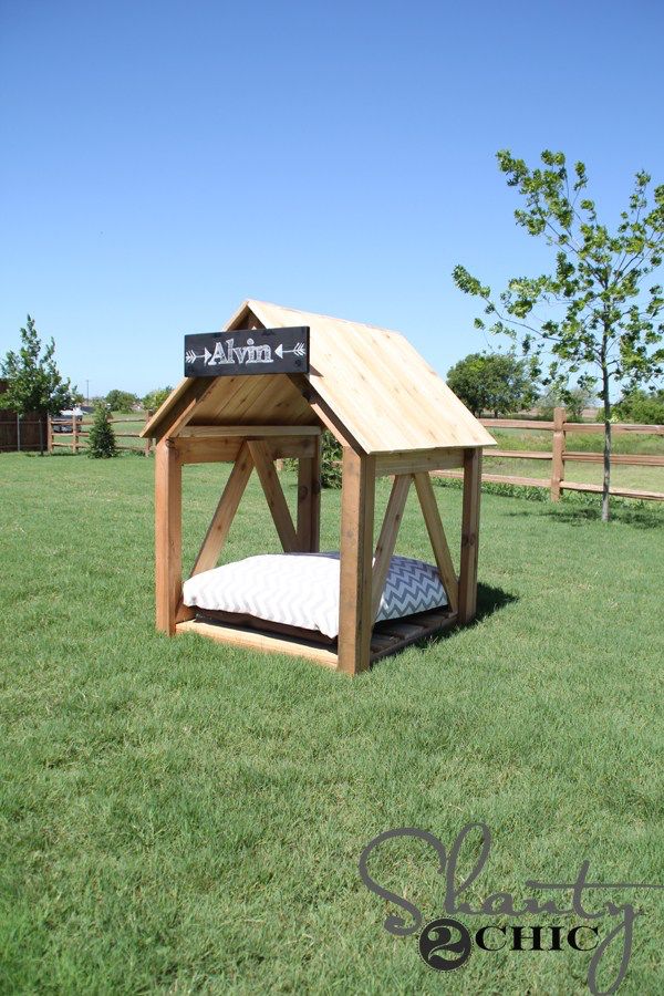 a dog house made out of pallet wood with a mattress in the top half