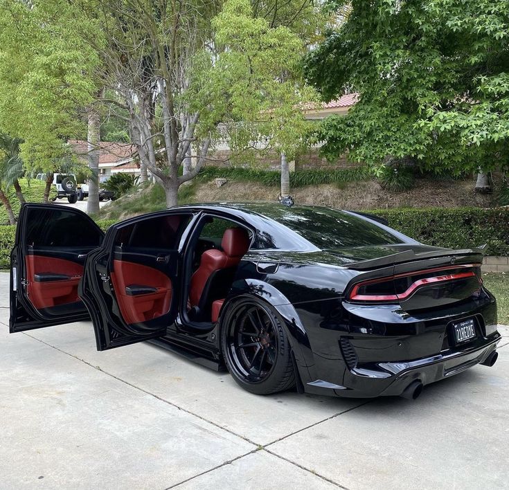 a black sports car with its doors open and the door ajar opened in front of it