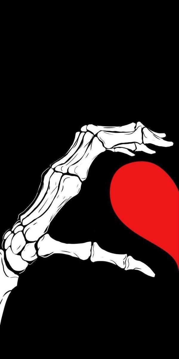 a skeleton hand holding a red heart on a black background