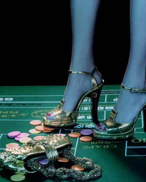 a pair of gold high heeled shoes sitting on top of a casino table