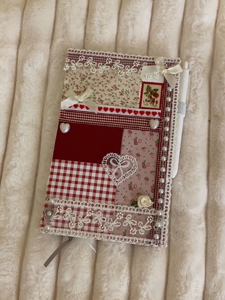 a small notebook with many different designs on it sitting on top of a white blanket