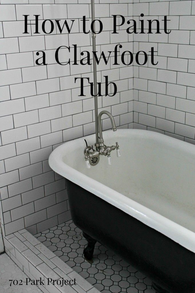 an old fashioned bathtub in a bathroom with white tiles on the walls and floor