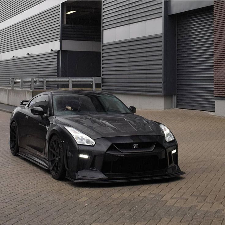 a black sports car parked in front of a building