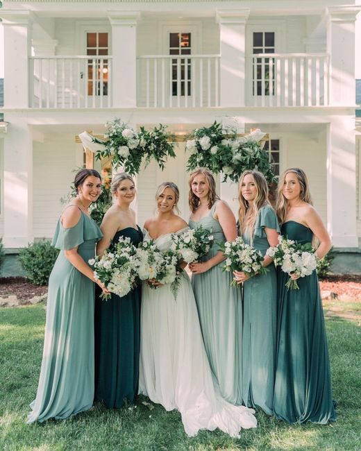 a group of women standing next to each other in front of a white house