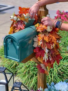 a person placing leaves on a mailbox