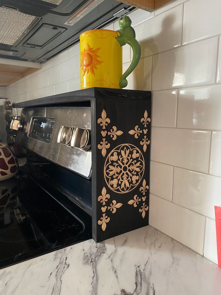 a black stove top oven sitting inside of a kitchen next to a white tiled wall