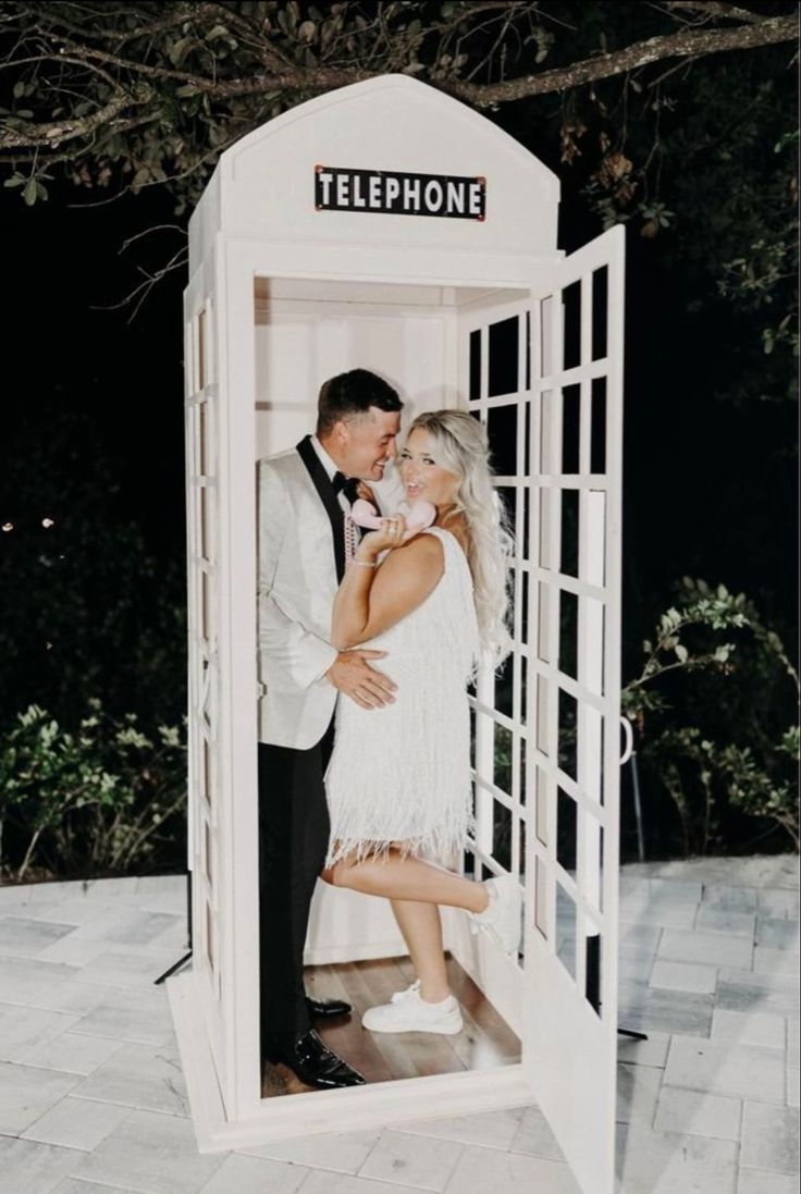 a man and woman standing in a phone booth