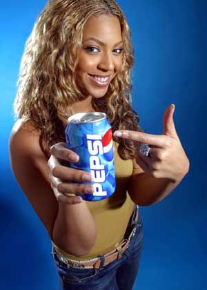 a woman holding a can of pepsi in her right hand and pointing at the camera