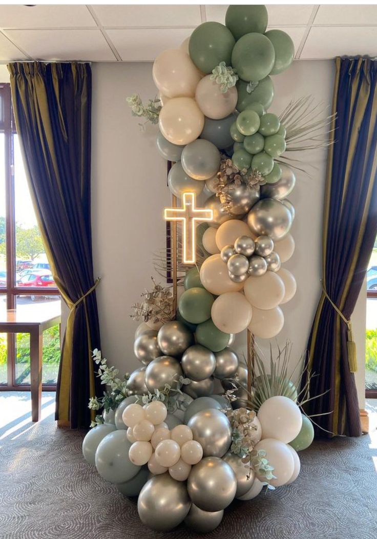 balloons and greenery are arranged in the shape of a cross