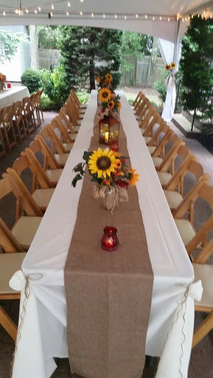 a long table set up with sunflowers and candles