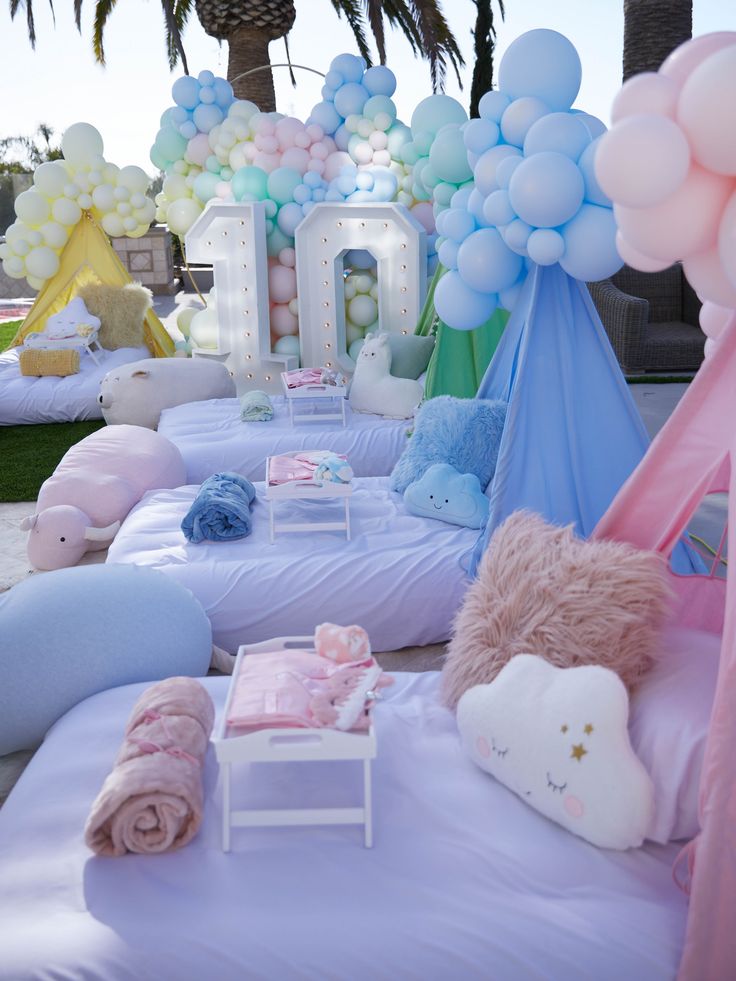 there are many balloons and decorations on the beach for a baby's first birthday